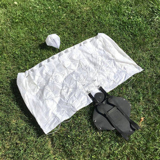 Toy white mini parachute on the grass.