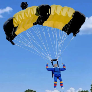 RC skydiver in the air with a black and yellow parachute.