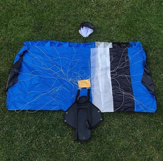 A blue mini parachute lying flat in the grass.