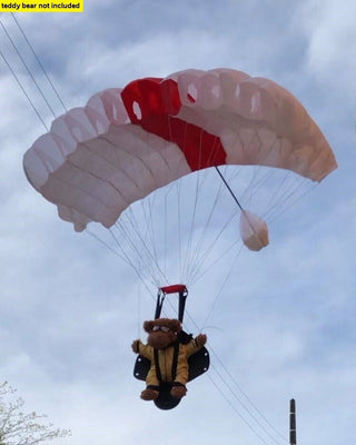 Teddy bear flying base jumping parachute.