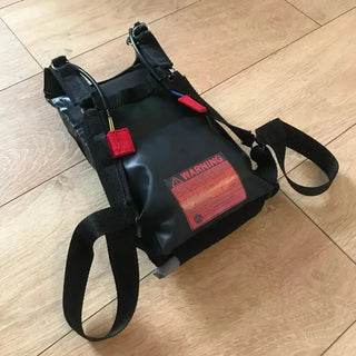 Skydiving rig harness with cutaway handles and 3 ring system and leg straps.